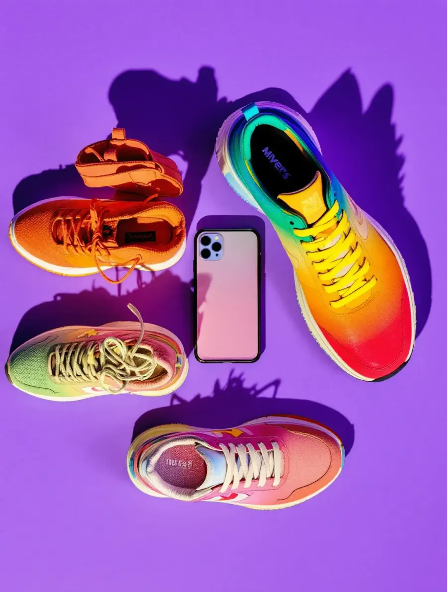 Kolorowe sneakersy i smartfon ułożone na fioletowym tle, kreacja reklamowa sklepu Krok