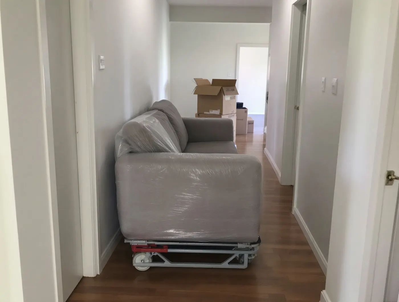 Sofa owinięta folią ochronną na wózku transportowym